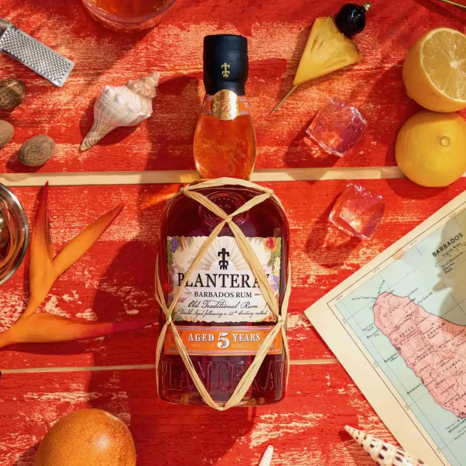 Bouteille de Rhum Planteray sur fond tropical rouge avec fruits, épices et carte de la Barbade.